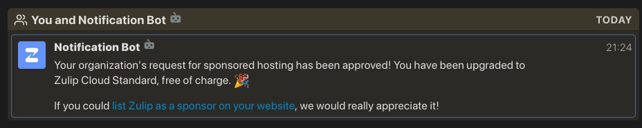 Screenshot of a dark-themed chat interface showing a message from Notification Bot at 21:24 with a blue Z logo icon. The message reads: Your organization's request for sponsored hosting has been approved! You have been upgraded to Zulip Cloud Standard, free of charge. followed by a party popper emoji. Below that, it says If you could list Zulip as a sponsor on your website, we would really appreciate it! with the phrase list Zulip as a sponsor on your website appearing as a blue hyperlink.