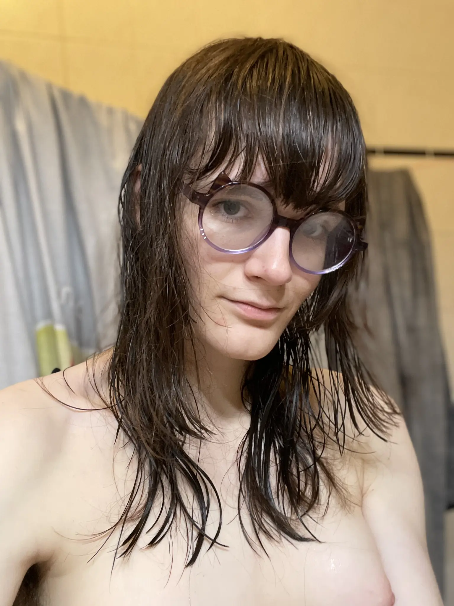 Same person with same haircut as described in other photograph. Close up selfie, person is nude with one of their bare breasts visible