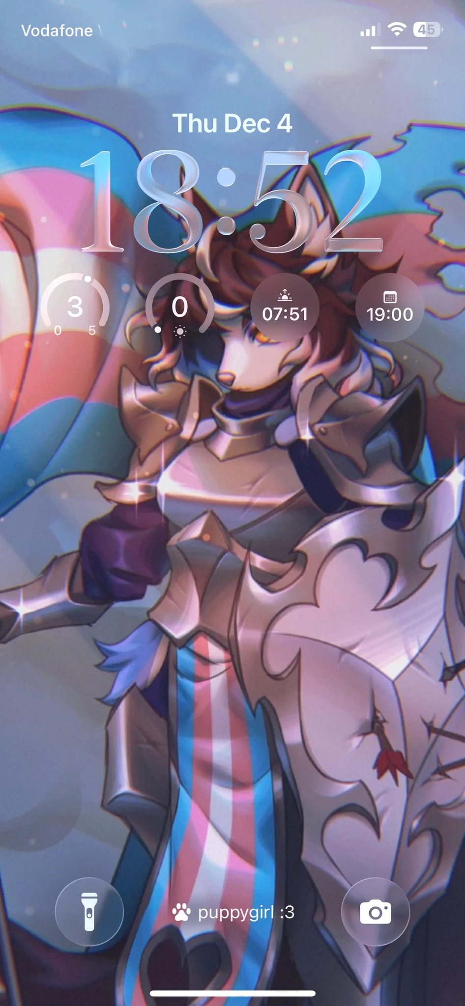 Photo of a smartphone lock screen displaying Thursday December 4 at 18:52, with Vodafone as the carrier showing 4G signal. The wallpaper features a digital illustration of an anthropomorphic dog character with flowing brown hair, shining armor, standing  while holding a huge trans flag in one hand and a large metal shield in the other. Additional UI elements show times 07:51 and 19:30, and at the bottom are three circular icons for flashlight, camera, and text reading puppygirl :3.